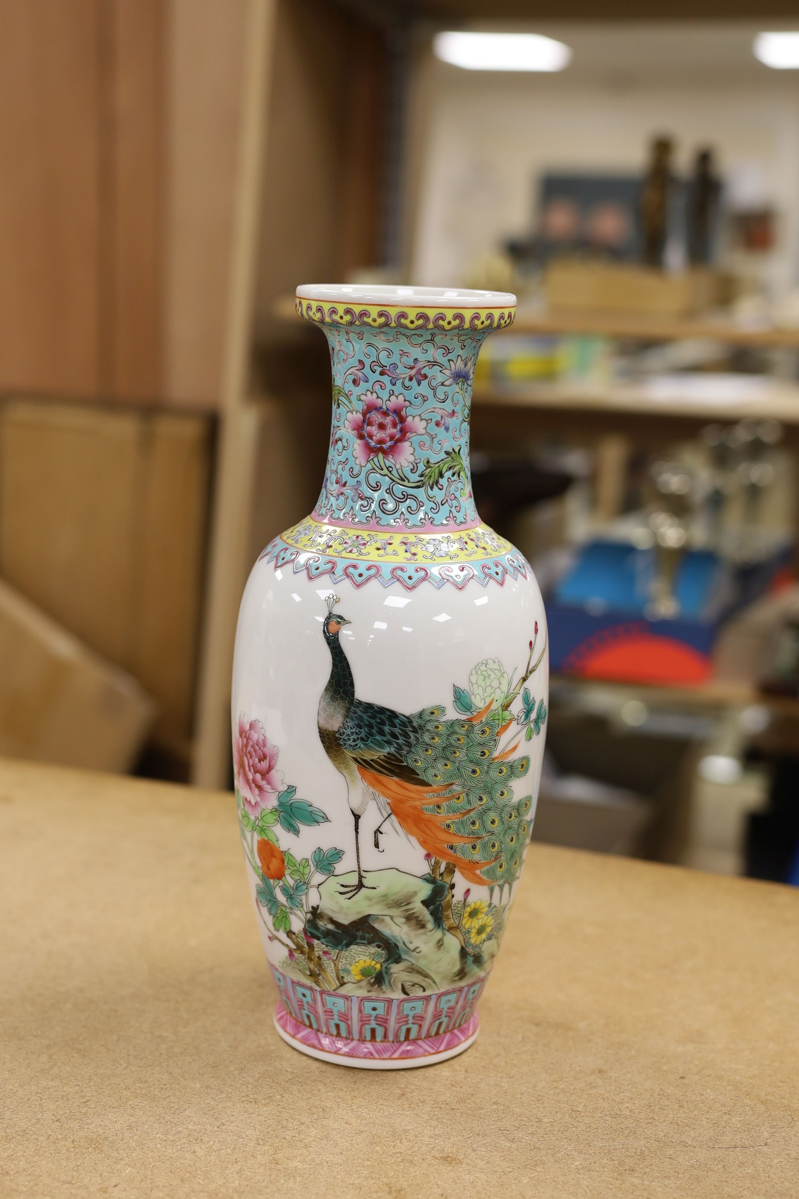 A pair of Chinese famille rose vases decorated with peacocks, 31cm